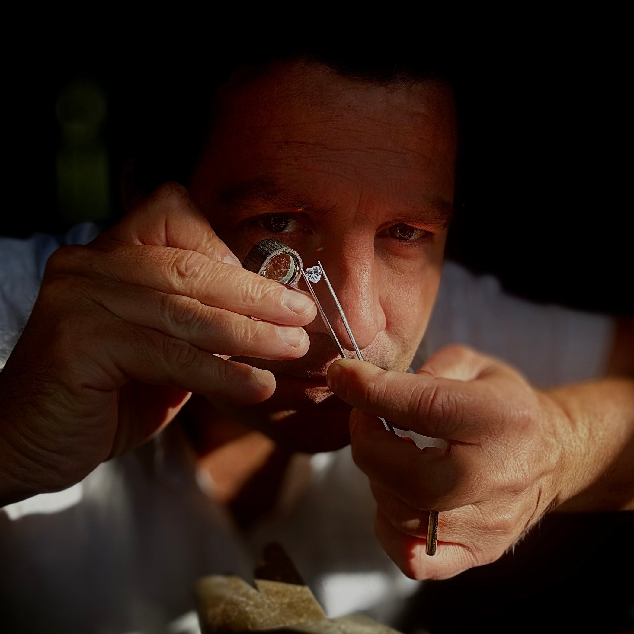 Erik Goemans, goudsmid in Zoetermeer, bekijkt een diamant tijdens het maken van een sieraad