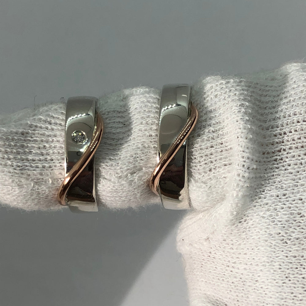 Handgemaakte trouwringen met organische vorm en subtiele diamant in goud en witgoud